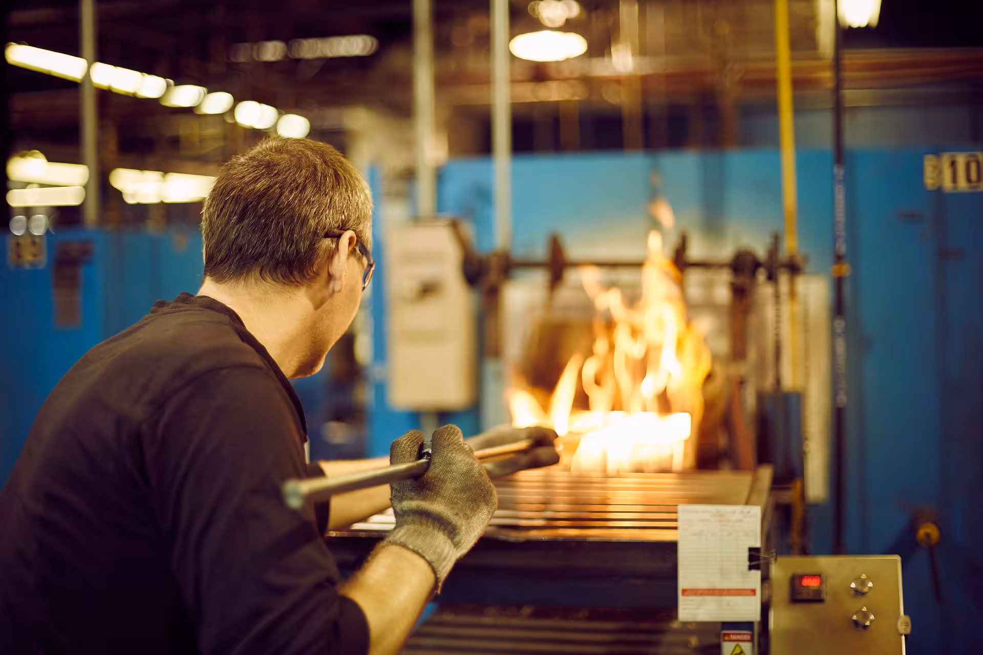 Worker operating industrial equipment at a Hanover manufacturing workplace.