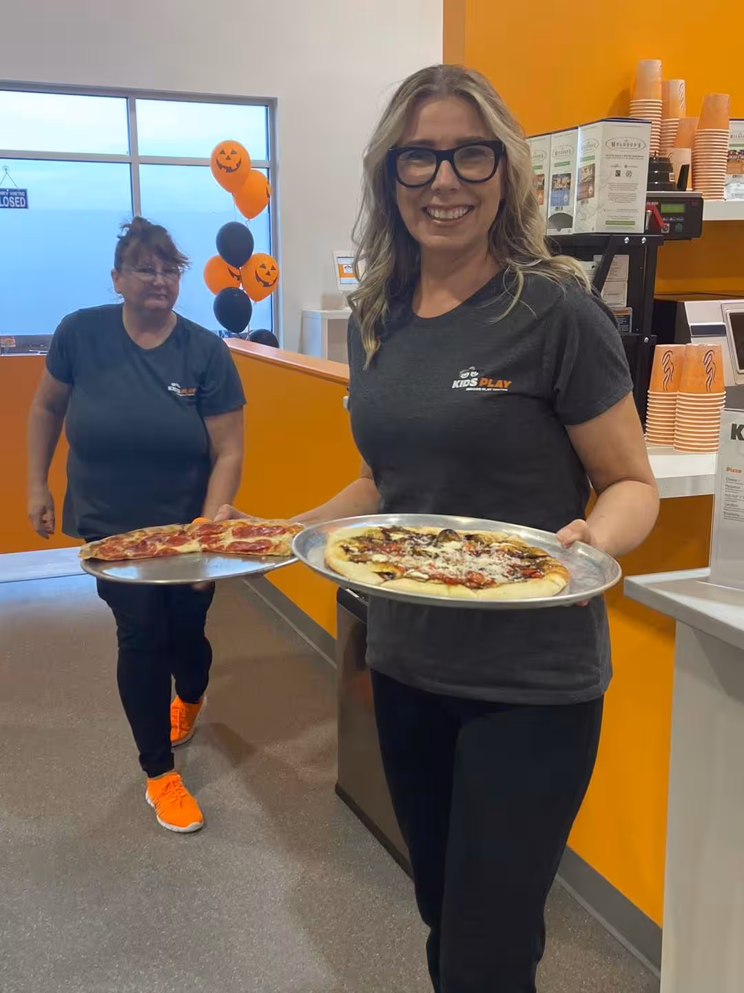 Two women holding a pizza during a WOWSA food business visit.
