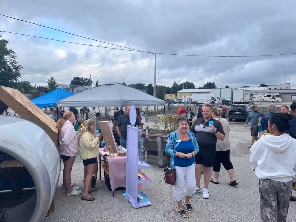 Young entrepreneurs and visitors at an outdoor youth market.