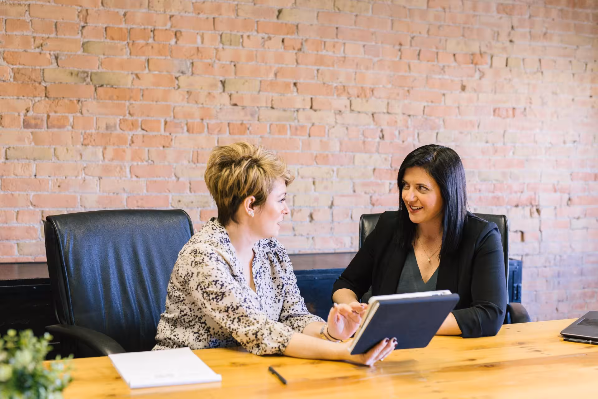 Two businesswomen meeting at a table.