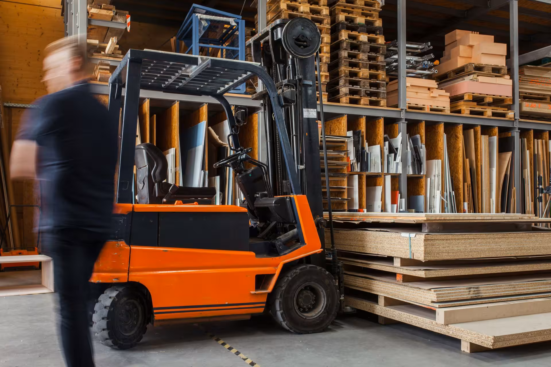 Worker driving a forklift in a warehouse.