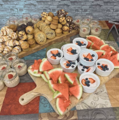 Refreshment table with baked goods, fruit, and yogurt.