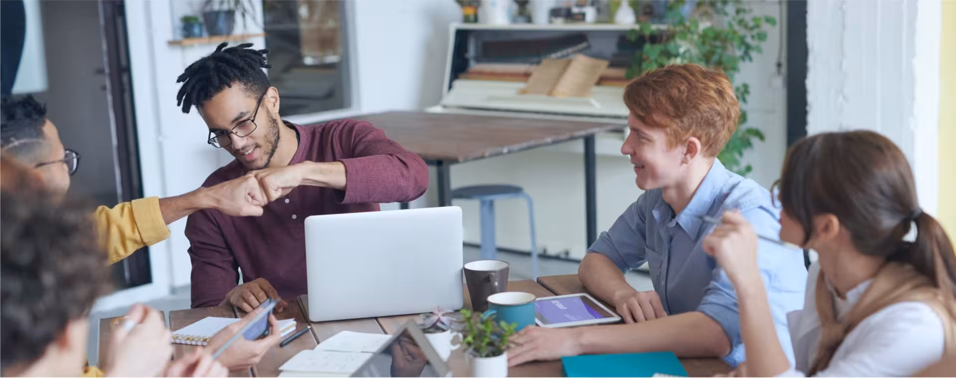 Diverse students collaborating around a workshop table.